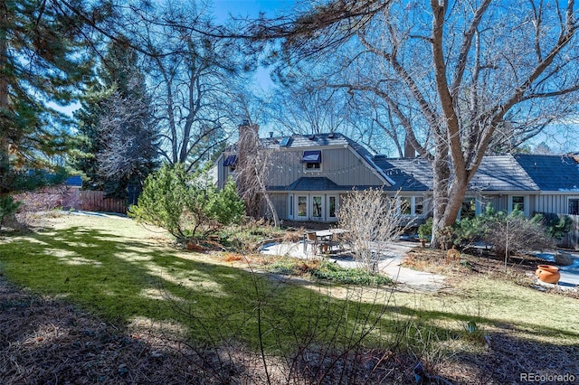 back of property with a patio area and a lawn