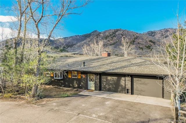 9610 Mohawk Trl, Cascade, CO 80809 - ranch-style house with roof with shingles, a garage, a chimney, and a mountain view