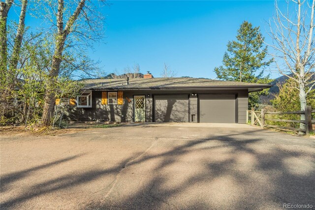 9610 Mohawk Trl, Cascade, CO 80809 - view of front of property featuring fence, an attached garage, concrete driveway, and a chimney
