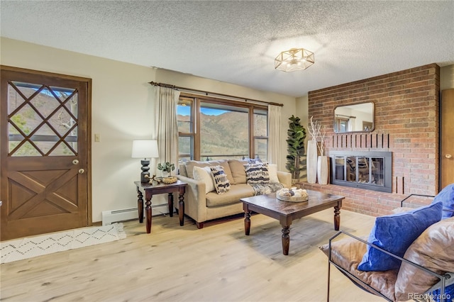 9610 Mohawk Trl, Cascade, CO 80809 - living area featuring baseboard heating, plenty of natural light, a textured ceiling, wood finished floors, and a brick fireplace