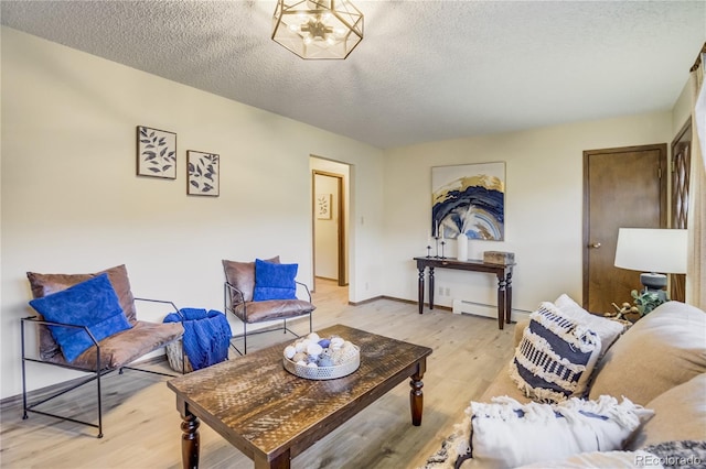 9610 Mohawk Trl, Cascade, CO 80809 - living room with light wood-style floors, a textured ceiling, a baseboard radiator, and baseboards