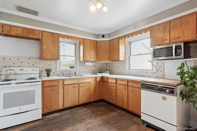 kitchen featuring dark wood-type flooring, white appliances, sink, and tasteful backsplash