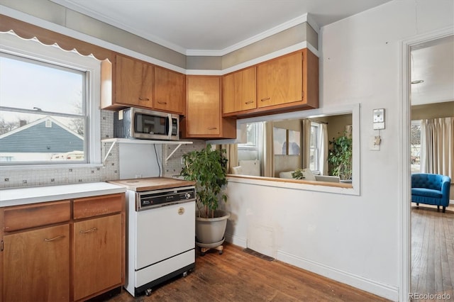 kitchen with tasteful backsplash, crown molding, dark hardwood / wood-style flooring, and range