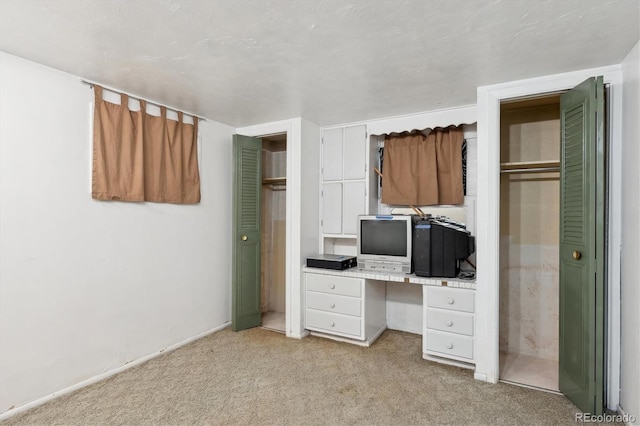 unfurnished bedroom with light colored carpet and built in desk