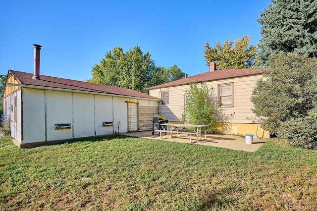 back of property with a patio area and a lawn