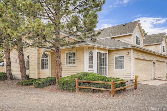 8346 S Upham Way, Littleton, CO 80128 - view of home's exterior with driveway, a shingled roof, and an attached garage
