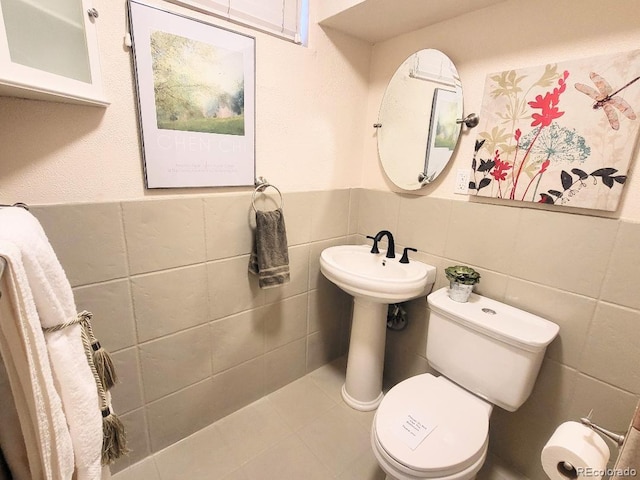 bathroom with tile walls and toilet