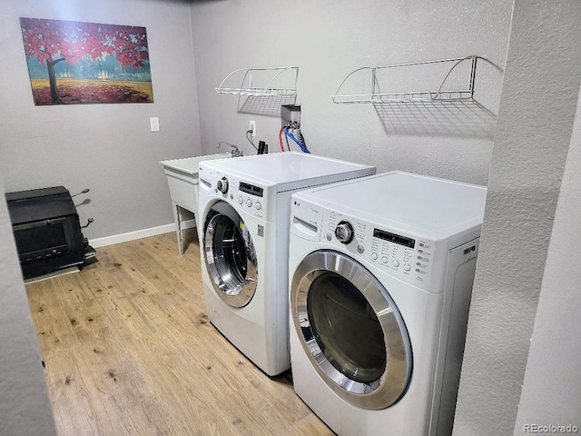 washroom with separate washer and dryer and light hardwood / wood-style flooring