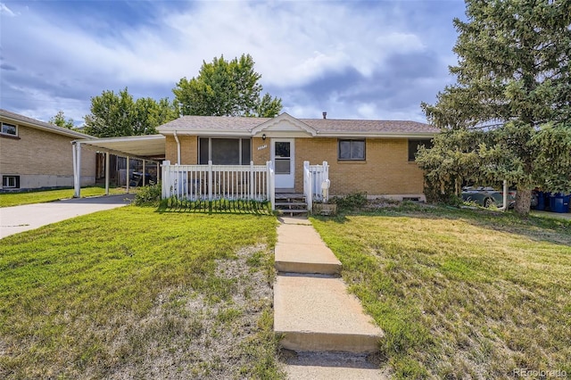 5673 Johnson St, Arvada, CO 80002 - view of front of home featuring brick siding, a front yard, concrete driveway, and an attached carport