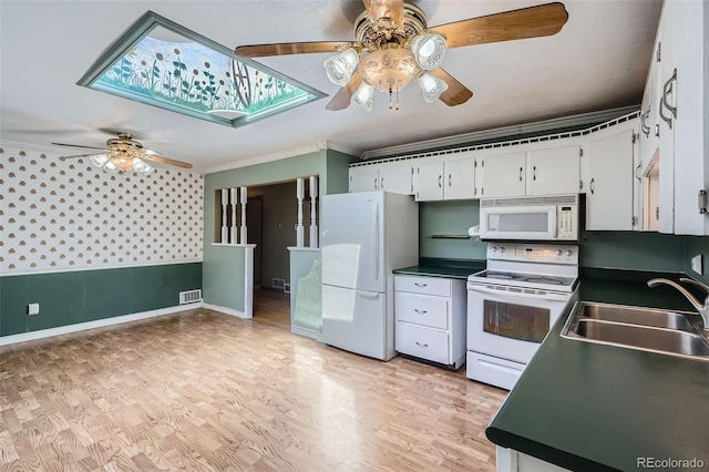5673 Johnson St, Arvada, CO 80002 - kitchen with white appliances, a ceiling fan, dark countertops, crown molding, and white cabinetry