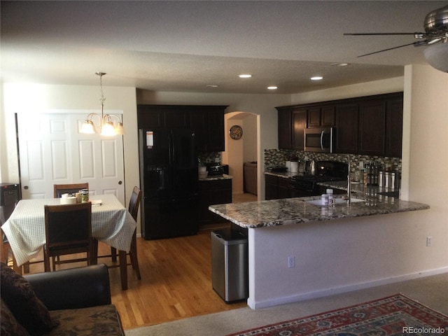 13674 Plaster Cir, Broomfield, CO 80023 - kitchen featuring black appliances, a ceiling fan, arched walkways, dark stone counters, and decorative backsplash