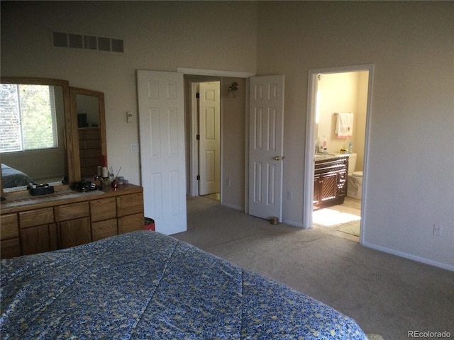 bedroom with carpet flooring and connected bathroom