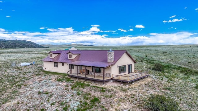1610 Timber Ridge Rd, Westcliffe, CO 81252 - back of property with stucco siding, a chimney, a deck, and a metal roof