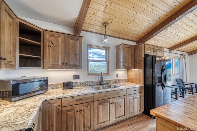 1610 Timber Ridge Rd, Westcliffe, CO 81252 - kitchen with stainless steel microwave, black fridge, light wood finished floors, healthy amount of natural light, and a wooden ceiling with exposed beams