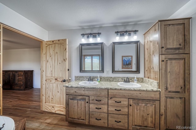 1610 Timber Ridge Rd, Westcliffe, CO 81252 - bathroom featuring wood finished floors, double vanity, and a textured ceiling