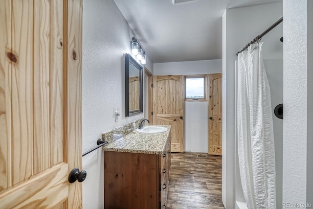 1610 Timber Ridge Rd, Westcliffe, CO 81252 - full bathroom featuring wood finished floors, vanity, a textured wall, curtained shower, and a textured ceiling