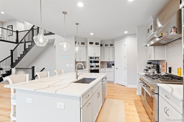 6614 S Vandriver Way, Aurora, CO 80016 - kitchen with appliances with stainless steel finishes, a kitchen bar, recessed lighting, wall chimney range hood, and decorative backsplash