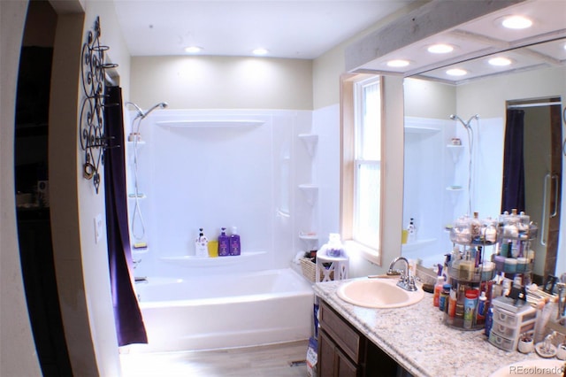 bathroom with recessed lighting, bathtub / shower combination, wood finished floors, and vanity