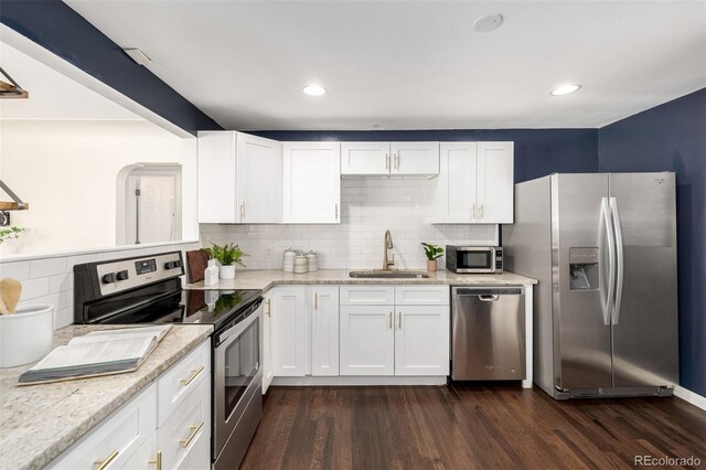 6390 W 45th Ave, Wheat Ridge, CO 80033 - kitchen featuring stainless steel appliances, tasteful backsplash, dark wood finished floors, white cabinets, and recessed lighting