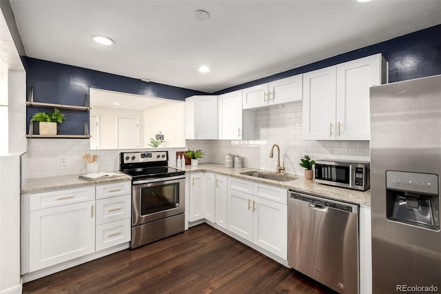 6390 W 45th Ave, Wheat Ridge, CO 80033 - kitchen with appliances with stainless steel finishes, white cabinets, light stone countertops, dark wood finished floors, and decorative backsplash