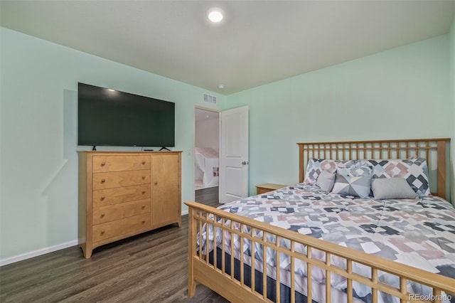 bedroom featuring baseboards, visible vents, and wood finished floors