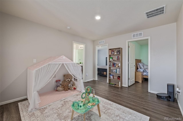 game room featuring baseboards, visible vents, and dark wood finished floors