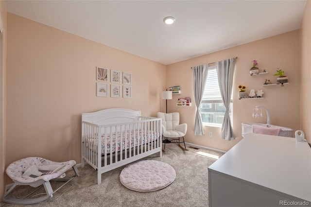 bedroom featuring carpet flooring, baseboards, and a crib