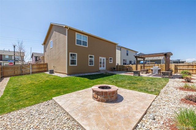 back of house with french doors, an outdoor fire pit, a yard, a fenced backyard, and a patio area