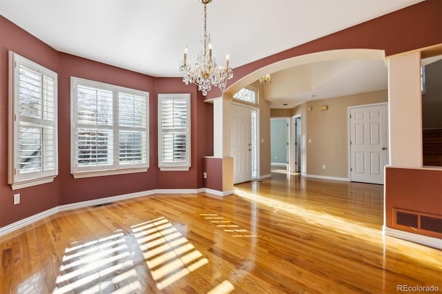 spare room featuring hardwood / wood-style floors and a notable chandelier