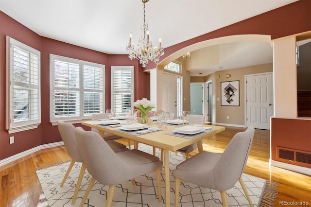 dining room with light wood-type flooring and a chandelier