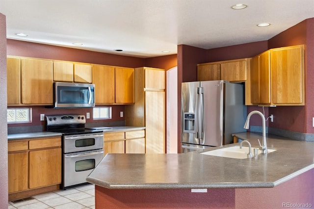 kitchen featuring light tile patterned flooring, appliances with stainless steel finishes, kitchen peninsula, and sink