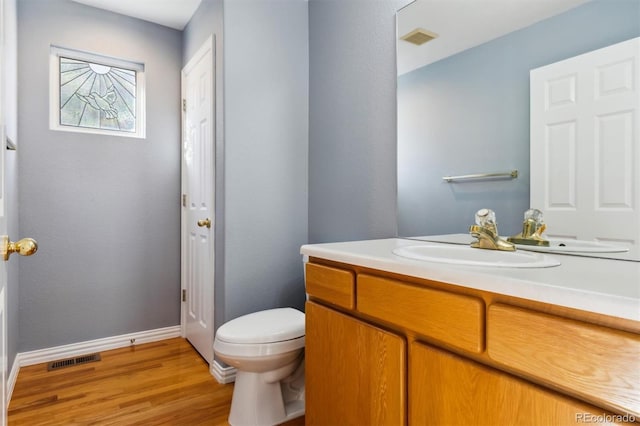 bathroom featuring wood-type flooring, vanity, and toilet