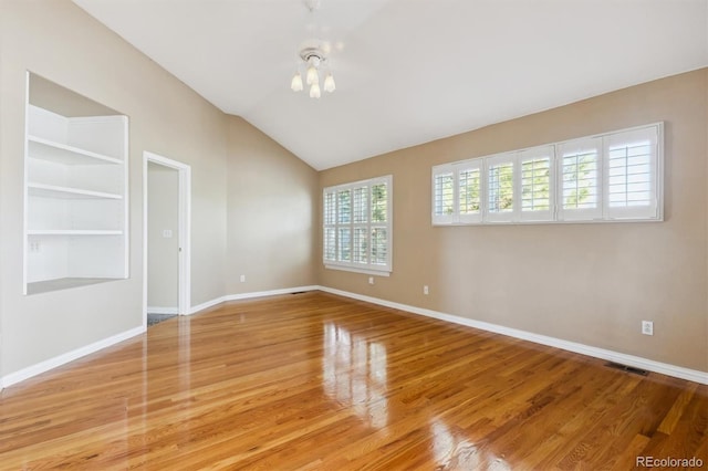 unfurnished room with light hardwood / wood-style floors and vaulted ceiling