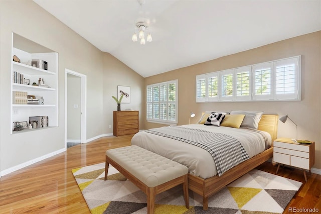 bedroom with wood-type flooring, vaulted ceiling, and multiple windows