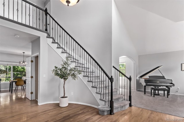 10345 Lions Heart, Lone Tree, CO 80124 - staircase with a towering ceiling, wood finished floors, baseboards, and arched walkways