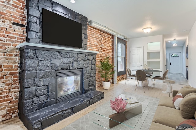 living room featuring a stone fireplace and hardwood / wood-style floors