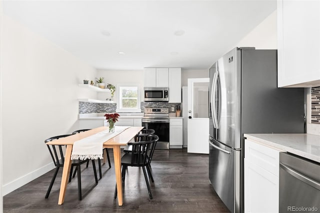 kitchen with backsplash, white cabinetry, stainless steel appliances, and dark hardwood / wood-style floors