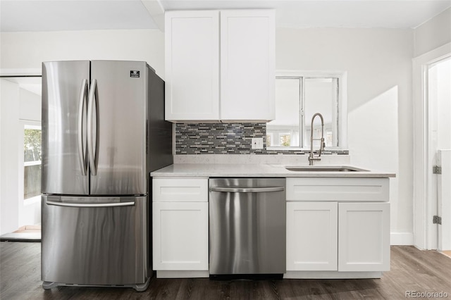 kitchen with sink, decorative backsplash, dark hardwood / wood-style flooring, white cabinetry, and stainless steel appliances