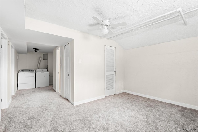 interior space featuring washer and dryer, a textured ceiling, light colored carpet, and ceiling fan