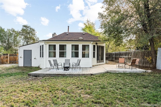 back of property featuring a lawn and a deck