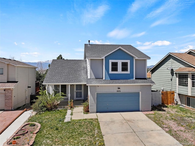 2970 Leoti Dr, Colorado Springs, CO 80922 - traditional home featuring a shingled roof, an attached garage, driveway, brick siding, and a mountain view