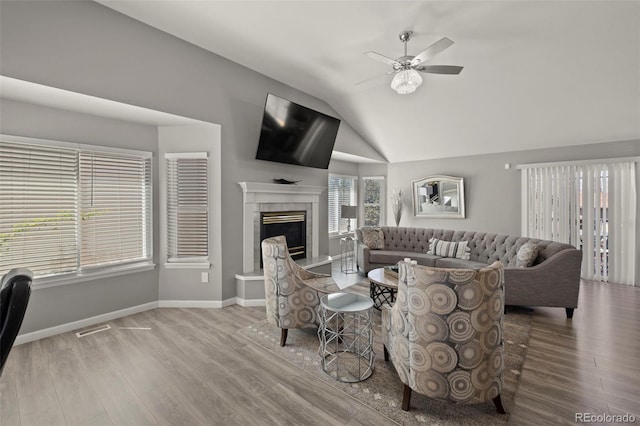 2970 Leoti Dr, Colorado Springs, CO 80922 - living room with wood finished floors, ceiling fan, lofted ceiling, a tile fireplace, and baseboards