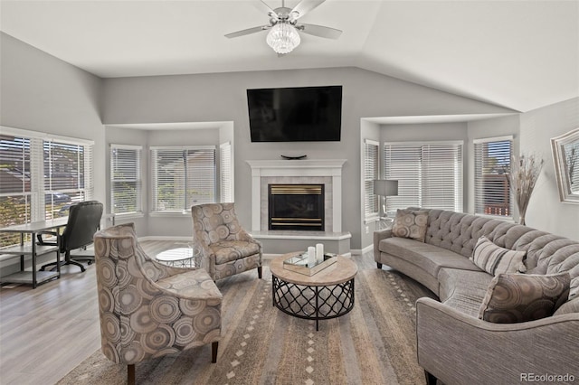 2970 Leoti Dr, Colorado Springs, CO 80922 - living room with wood finished floors, a tile fireplace, vaulted ceiling, healthy amount of natural light, and a ceiling fan