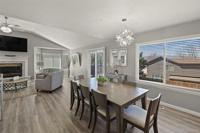 2970 Leoti Dr, Colorado Springs, CO 80922 - dining area with wood finished floors, baseboards, a fireplace, lofted ceiling, and a ceiling fan