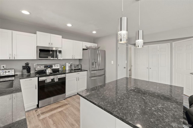 2970 Leoti Dr, Colorado Springs, CO 80922 - kitchen featuring appliances with stainless steel finishes, light wood-type flooring, white cabinetry, recessed lighting, and hanging light fixtures