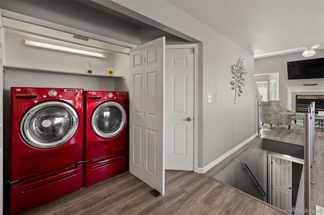 2970 Leoti Dr, Colorado Springs, CO 80922 - laundry area featuring washing machine and clothes dryer, wood finished floors, a fireplace, and baseboards