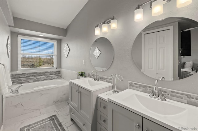 2970 Leoti Dr, Colorado Springs, CO 80922 - full bathroom featuring marble look tile flooring, two vanities, a garden tub, and lofted ceiling
