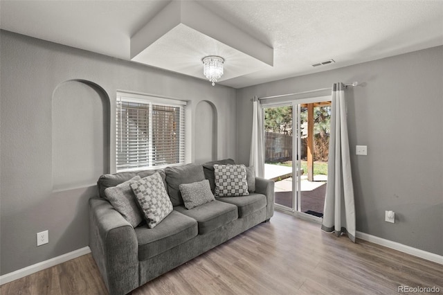 2970 Leoti Dr, Colorado Springs, CO 80922 - living area with wood finished floors, baseboards, a chandelier, and arched walkways