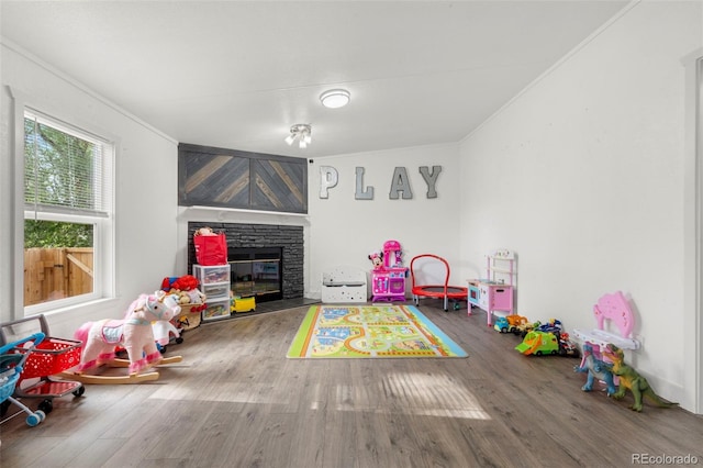 811 Plum Ave N, Lochbuie, CO 80603 - recreation room with crown molding, a fireplace, and wood finished floors
