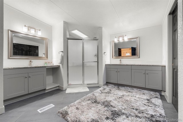 811 Plum Ave N, Lochbuie, CO 80603 - bathroom featuring a shower stall, two vanities, and tile patterned flooring